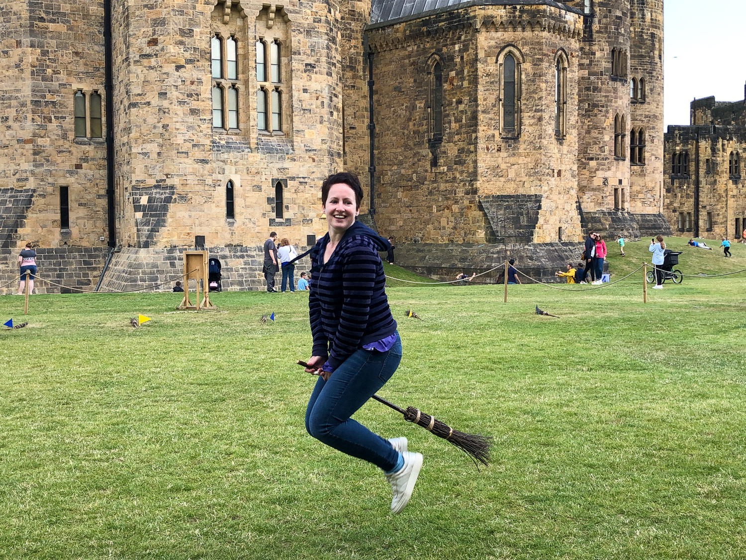 Photo of me sitting on a broomstick apparently suspended in midair during a visit with kids to Alnwick Castle