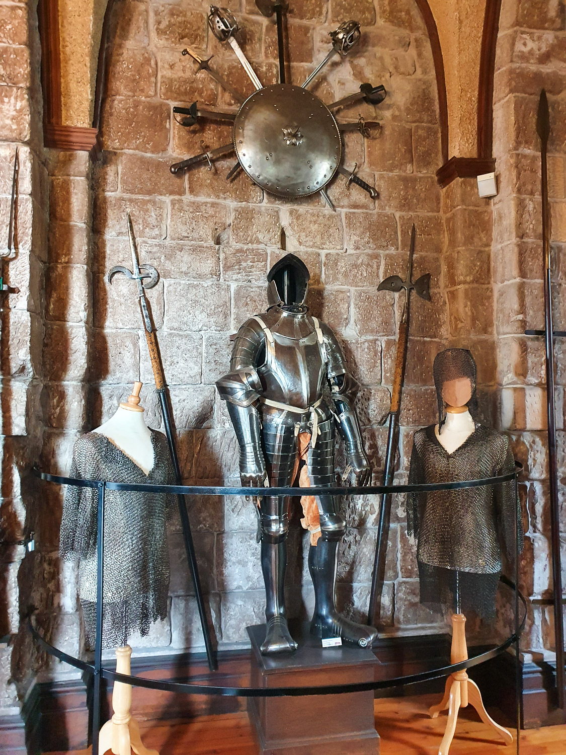 Armour and chain mail on display under weapons during a visit to Bamburgh Castle with kids