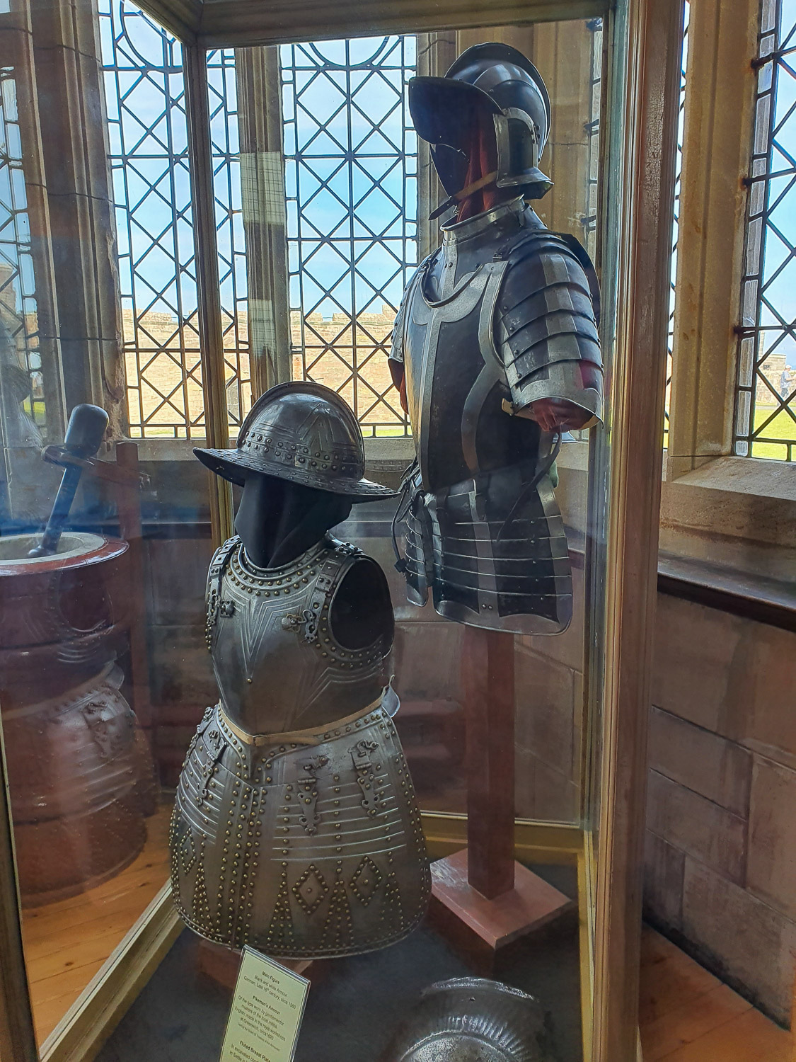Two suits of armour in a glass case, in one of the window alcoves of Bamburgh Castle, Northumberland