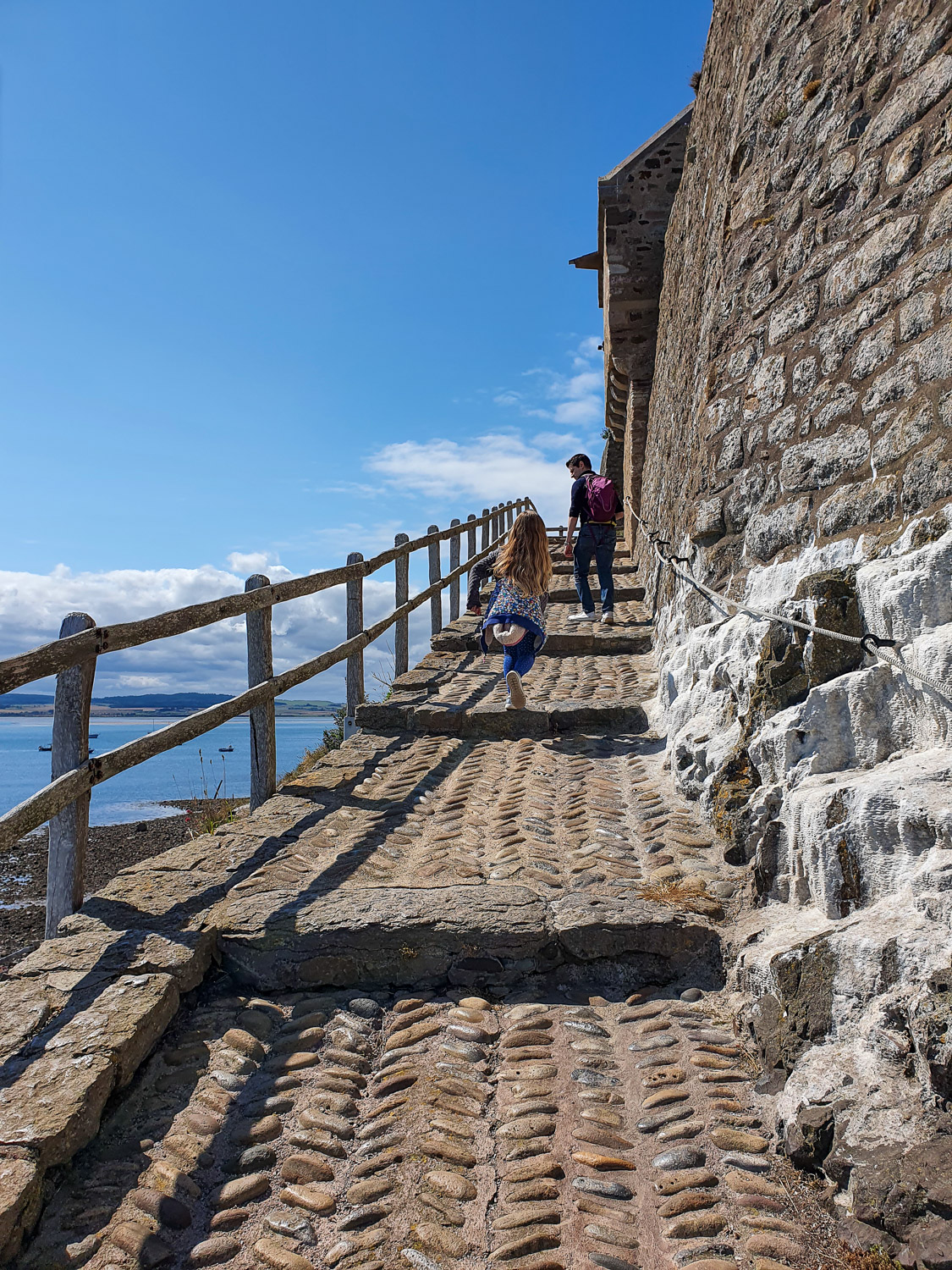 My daughter walks up the cobbled slope to the entrance to Lindisfarne Castle during a family day out on Holy Island, Northumberland