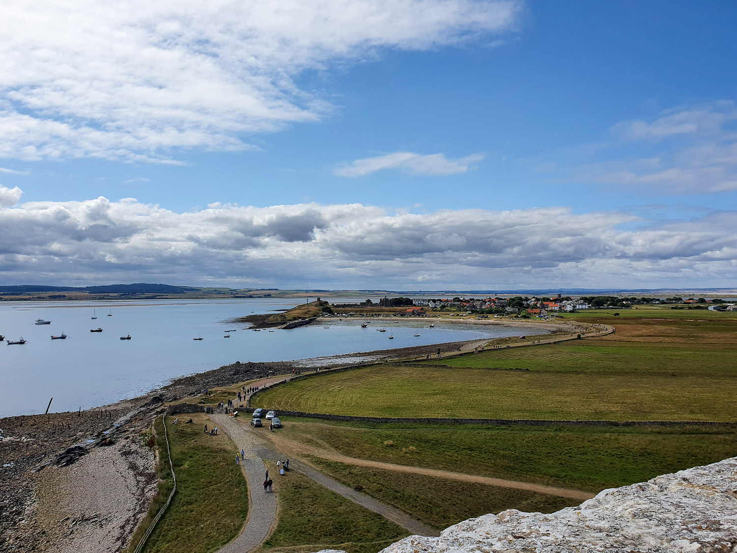 View from over the walls of the Upper Battery back towards the harbour on Holy Island, Northumberland during a day out on Lindisfarne with kids