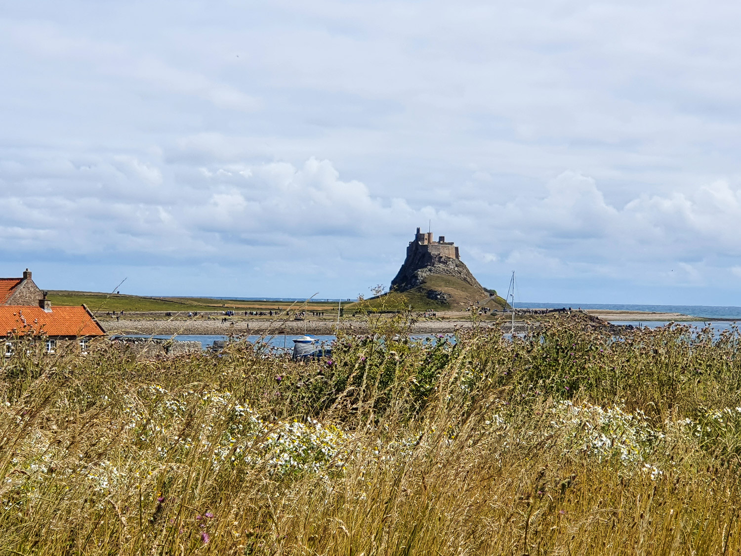 View from Lindisfarne Priory across the water to Lindisfarne Castle during a day on Holy Island, Northumberland with kids