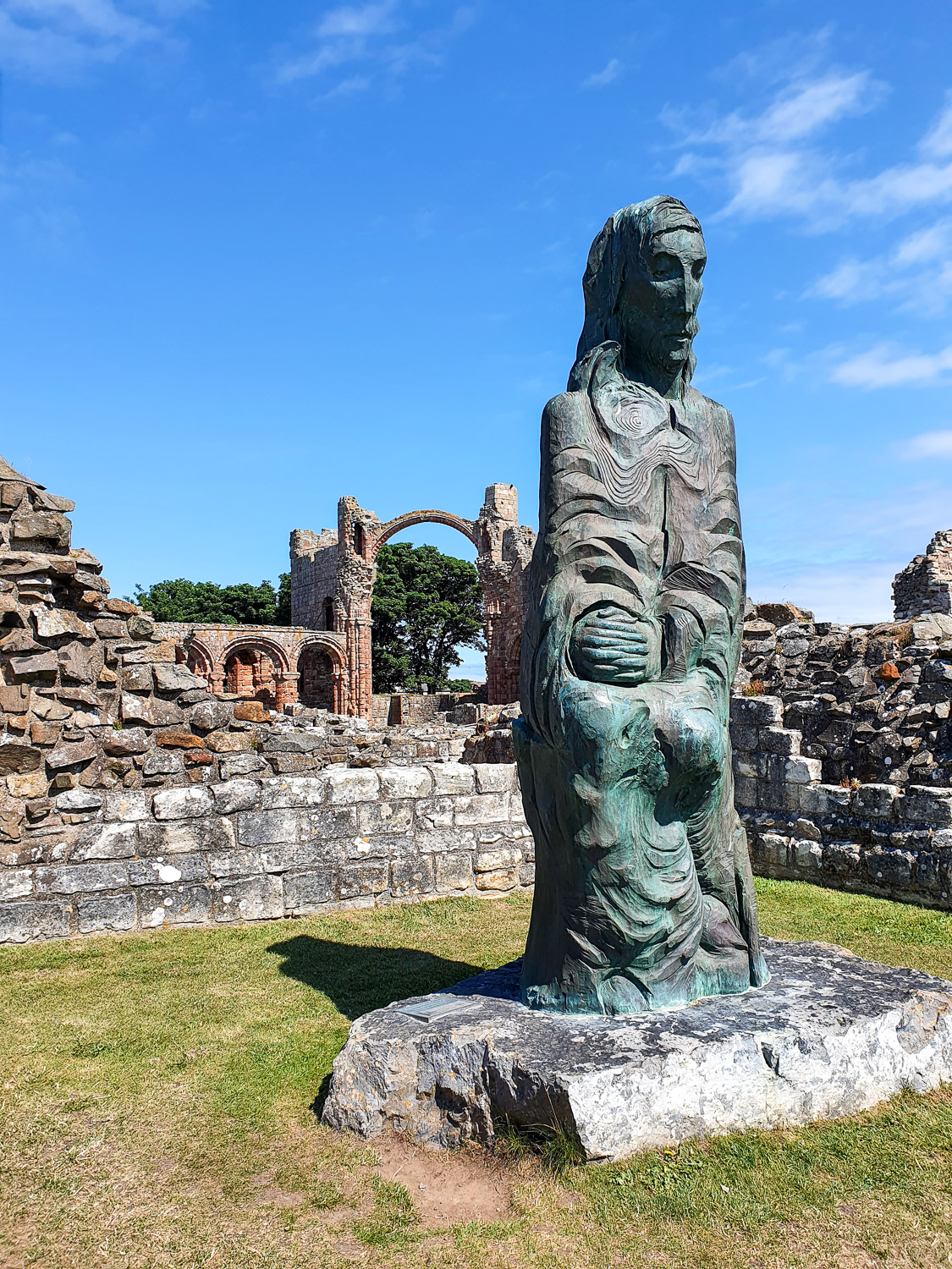View of a metal figure within the grounds of Lindisfarne Priory on a family day out in Northumberland
