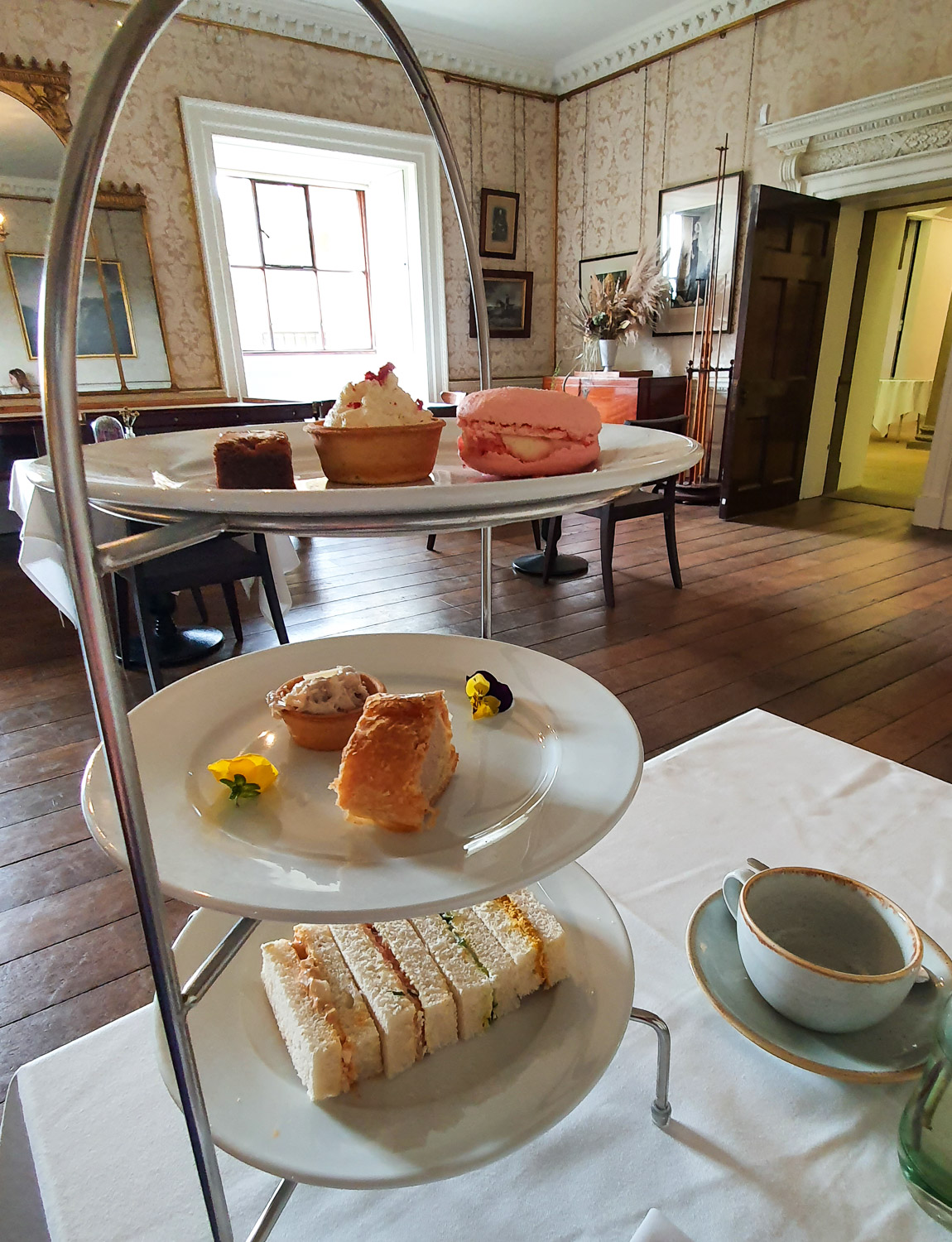 Three tier tray with afternoon tea, including sandwiches and cakes, in the old billiard room at Harewood House, Leeds