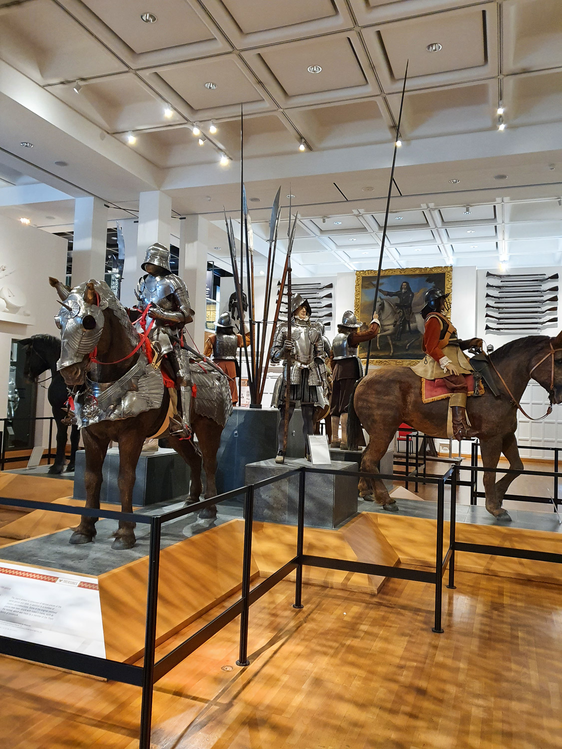 Display of men, some foot soldiers and some mounted, as well as horses in armour in one of the main display halls at the Royal Armouries