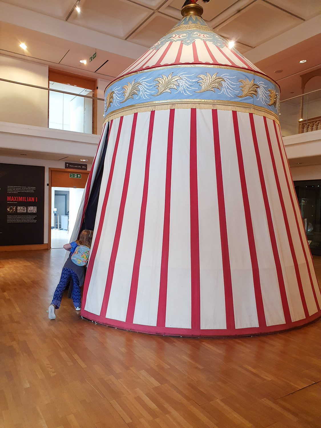 My daughter peeks inside a striped tent in the Field of the Cloth of Gold exhibition at the Royal Armouries in Leeds
