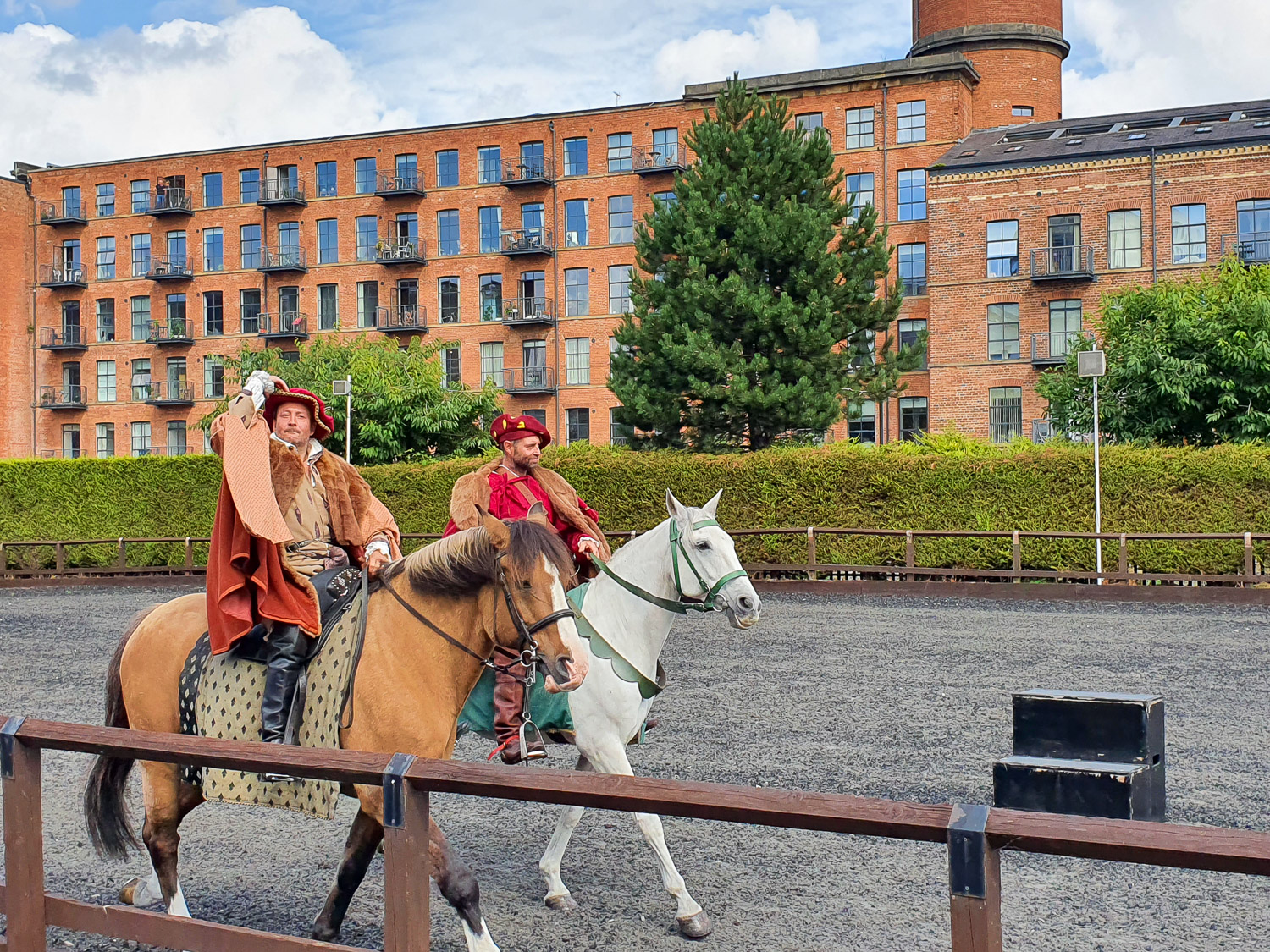 Two riders in the tiltyard, one posed to doff his cap, as they prepare for a show of Tudor skills with the sword and lance - a highlight of a day at the Royal Armouries with kids