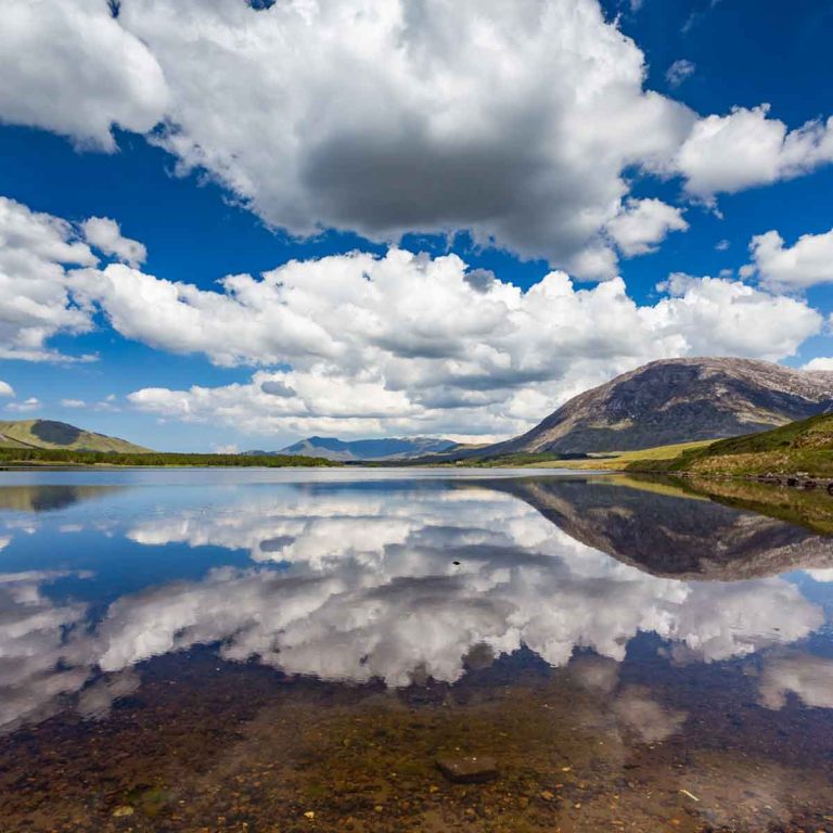 View of the landscape and clouds reflected in a lake in Connemara National Park - one of the best days out from Galway