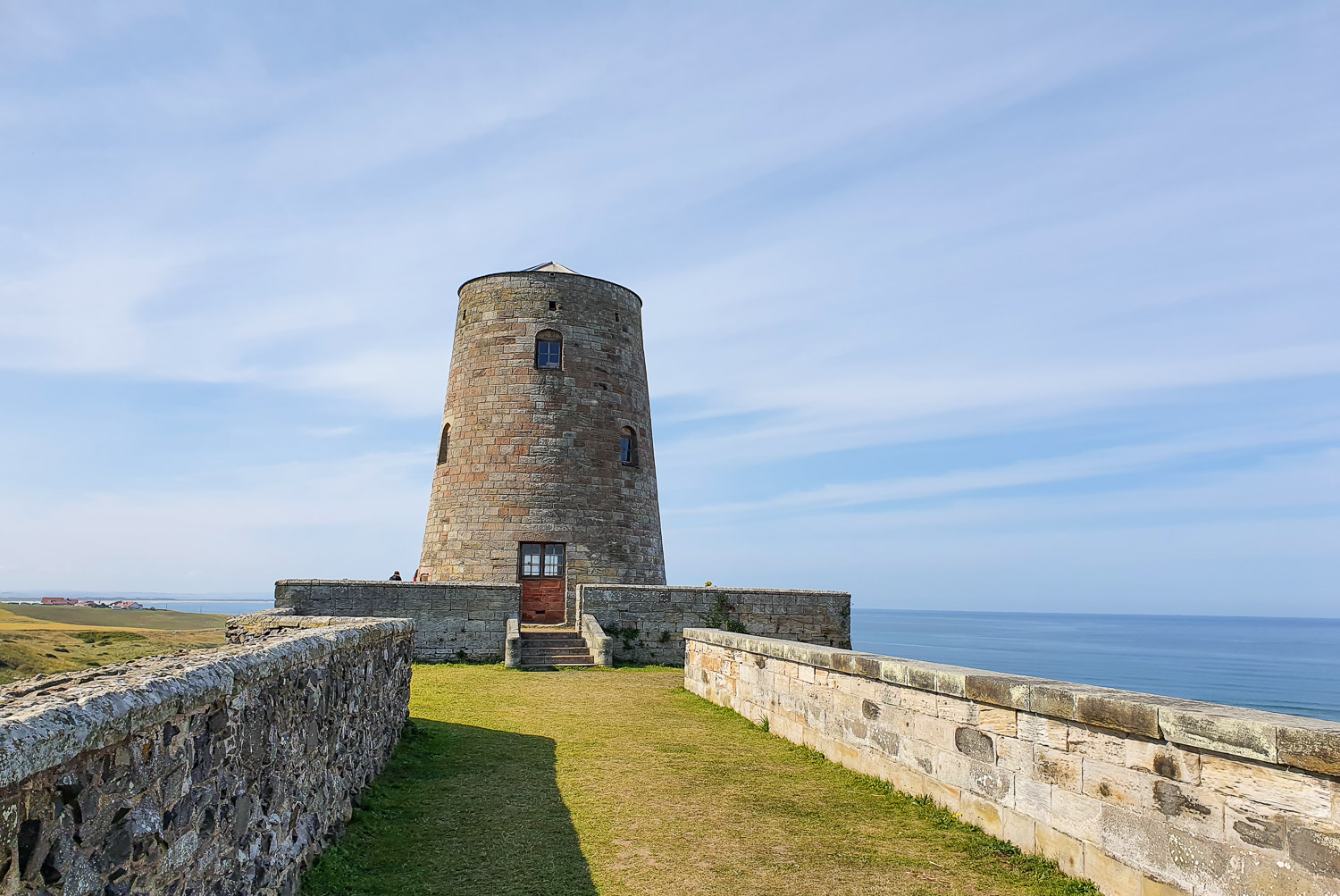 View to the old windmill in the grounds of Bamburgh Castle during a family day out in Northumberland
