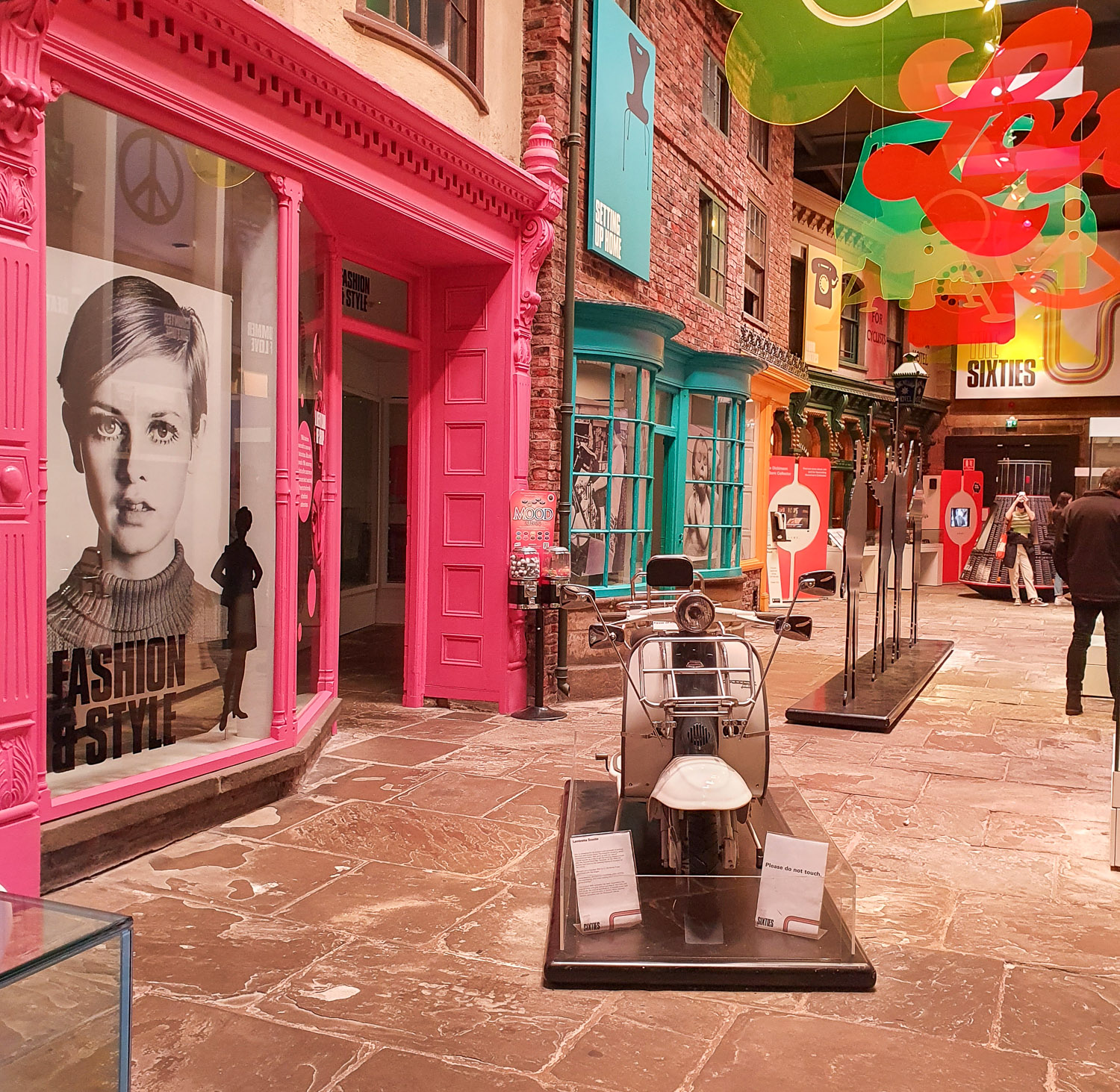 View of the 60s exhibits with a street of brightly coloured shop windows and 60s icons including Twiggy - my review of York Castle Museum with kids