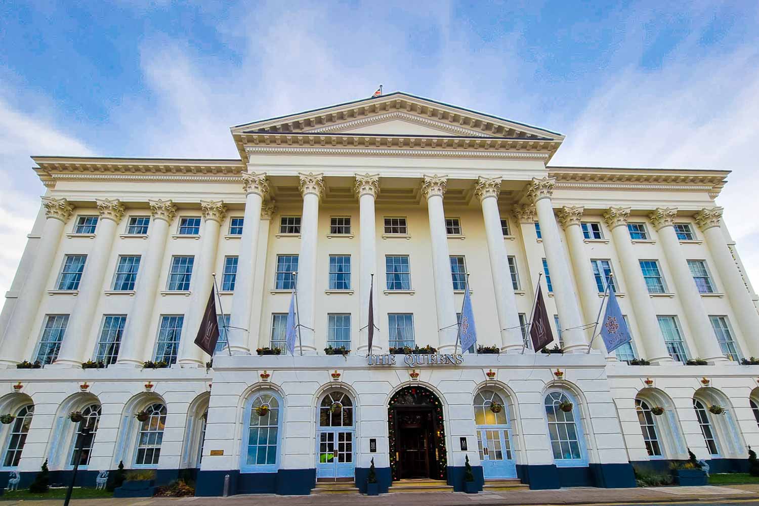 Facade of the Queens hotel in Cheltenham, white Palladian architecture against a blue sky - my base for discovering the best things to do in Cheltenham with kids
