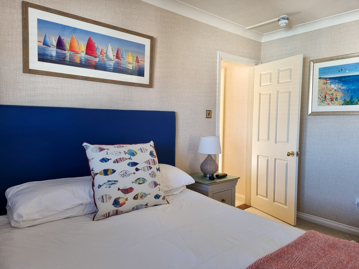 View of the double bed in the main bedroom, with sea themed artwork, in the penthouse at the Beachcroft hotel Felpham - my review of a stay at the Sussex hotel with kids
