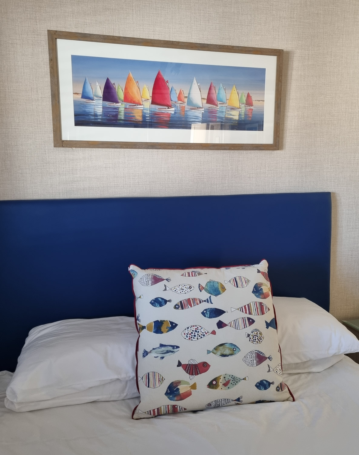 View of the fish decorated cushion and boat artwork above the bed in the main bedroom of the penthouse at the Beachcroft hotel Felpham - my review of a stay at the Sussex hotel with kids