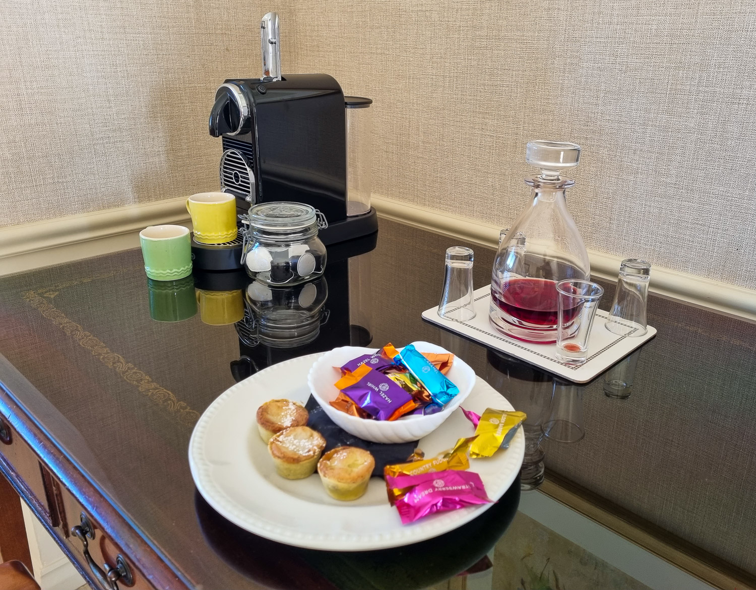 Nespresso machine with decanter of sloe gin plus glasses, mugs and a plate of chocolates and mini mince pies in the penthouse at the Beachcroft hotel Felpham - my review of a stay at the Sussex hotel with kids