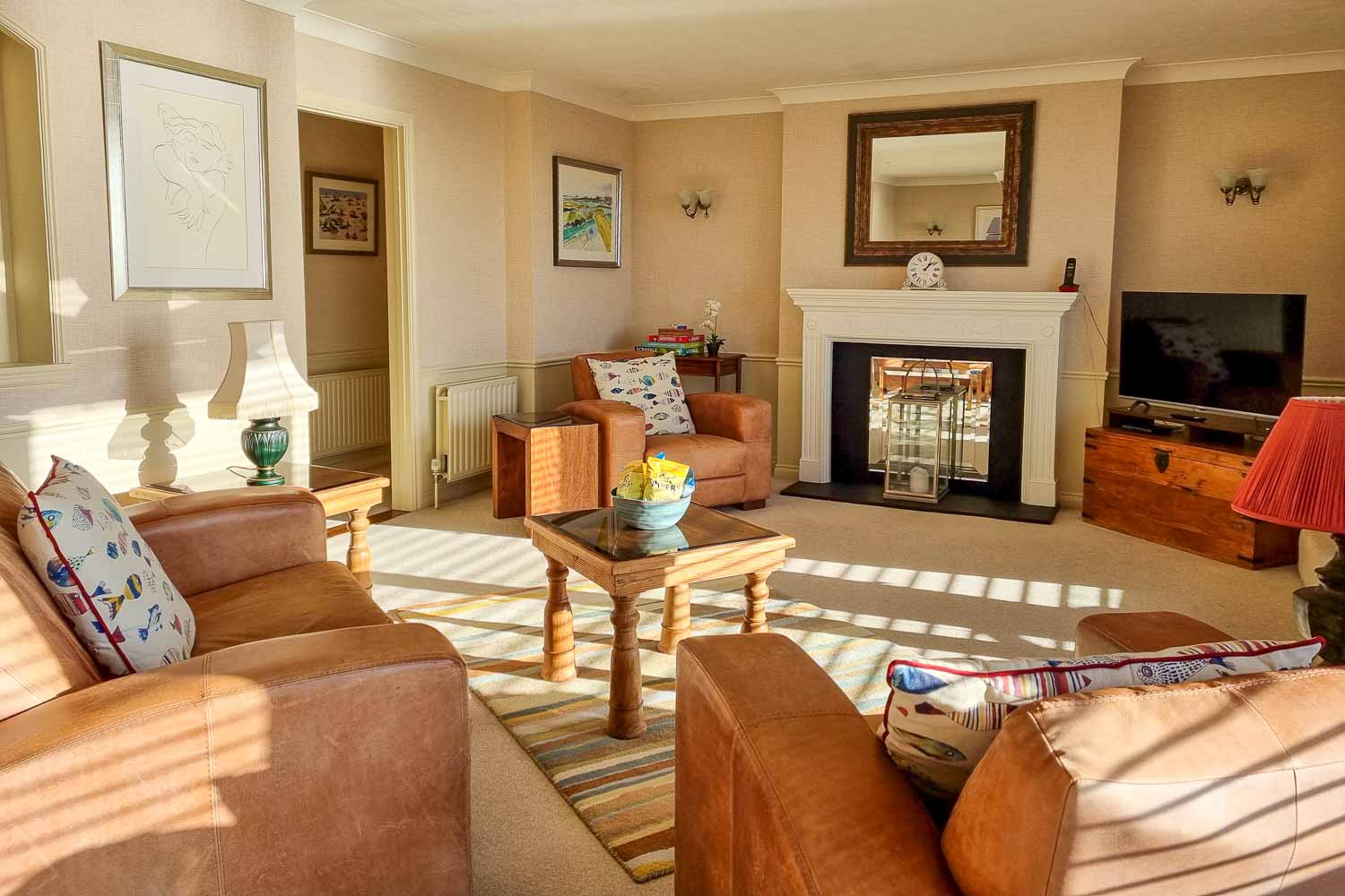 View of the living area with brown leather chairs, fish cushions and TV in the penthouse at the Beachcroft hotel Felpham - my review of a stay at the Sussex hotel with kids