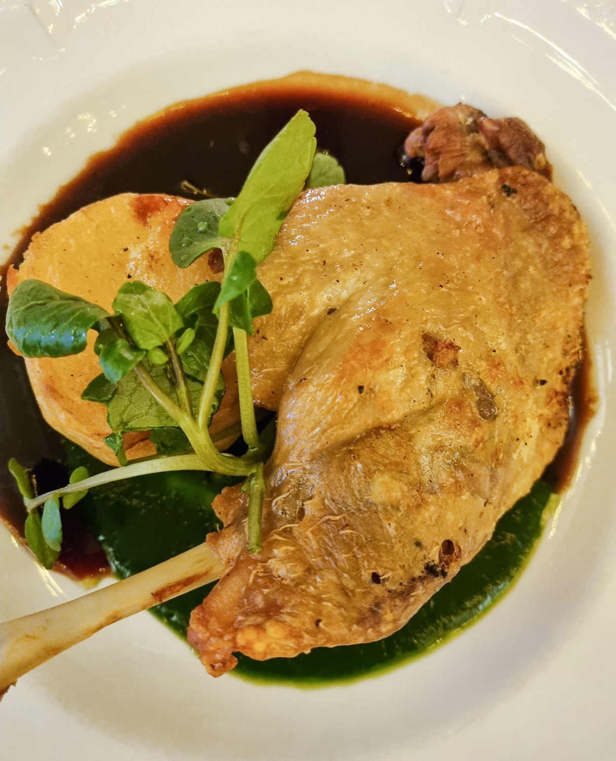 Confit duck leg with potato and greens on a plate in the restaurant of the Beachcroft Hotel in Sussex, part of their Christmas menu in the restaurant