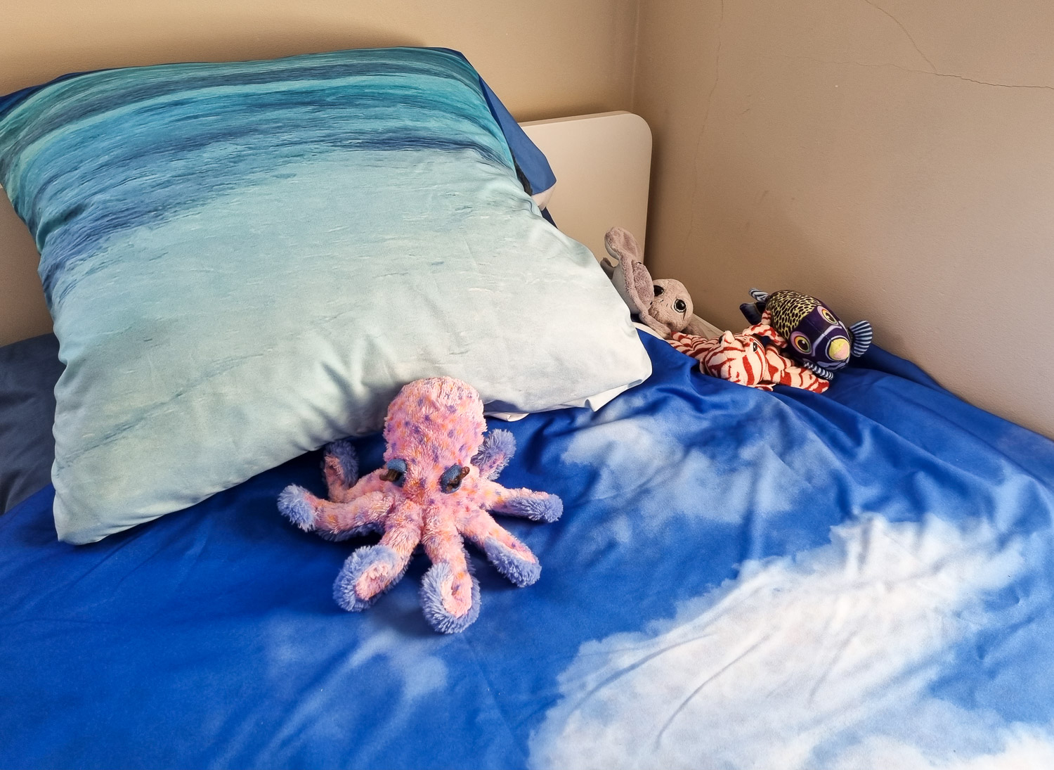 Stuffed animals, including fish and octopus on my daughter's bed on the photo printed bedlinen created as part of a My Picture photo printing review