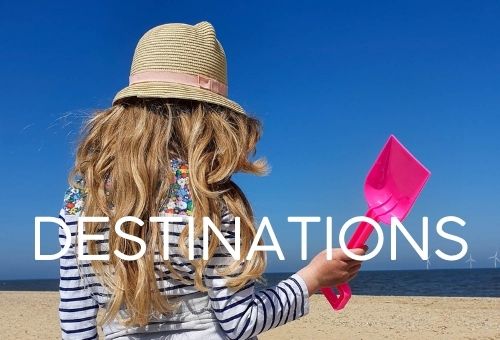 Image showing a girl on a beach holding a pink plastic spade with the word destinations - linking to family travel posts on destinations around the world
