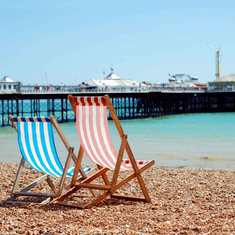 Deckchairs on the beach in Brighton with the pier in the background -if you're visiting the British seaside, here are my top things to do in Brighton with kids