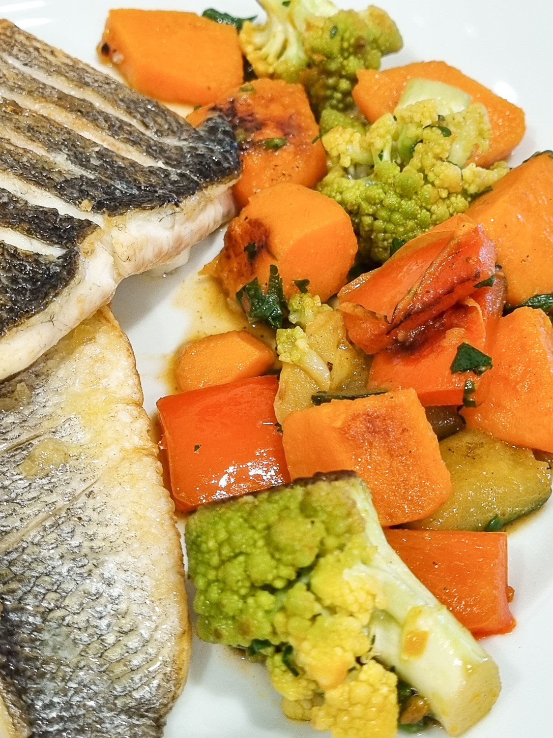 Close-up view of sea bass with sweet potato and romanesco cauliflower on a white plate - enjoying our lunch after our Lisbon cooking workshop for families