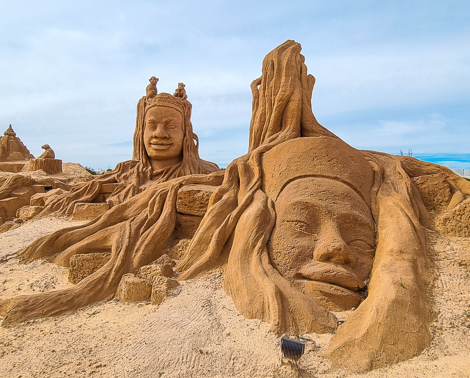 Recreation of Cambodian temple including huge heads wrapped in trees and monkeys at Sand City Lagoa - one of my top things to do in the Algarve with kids