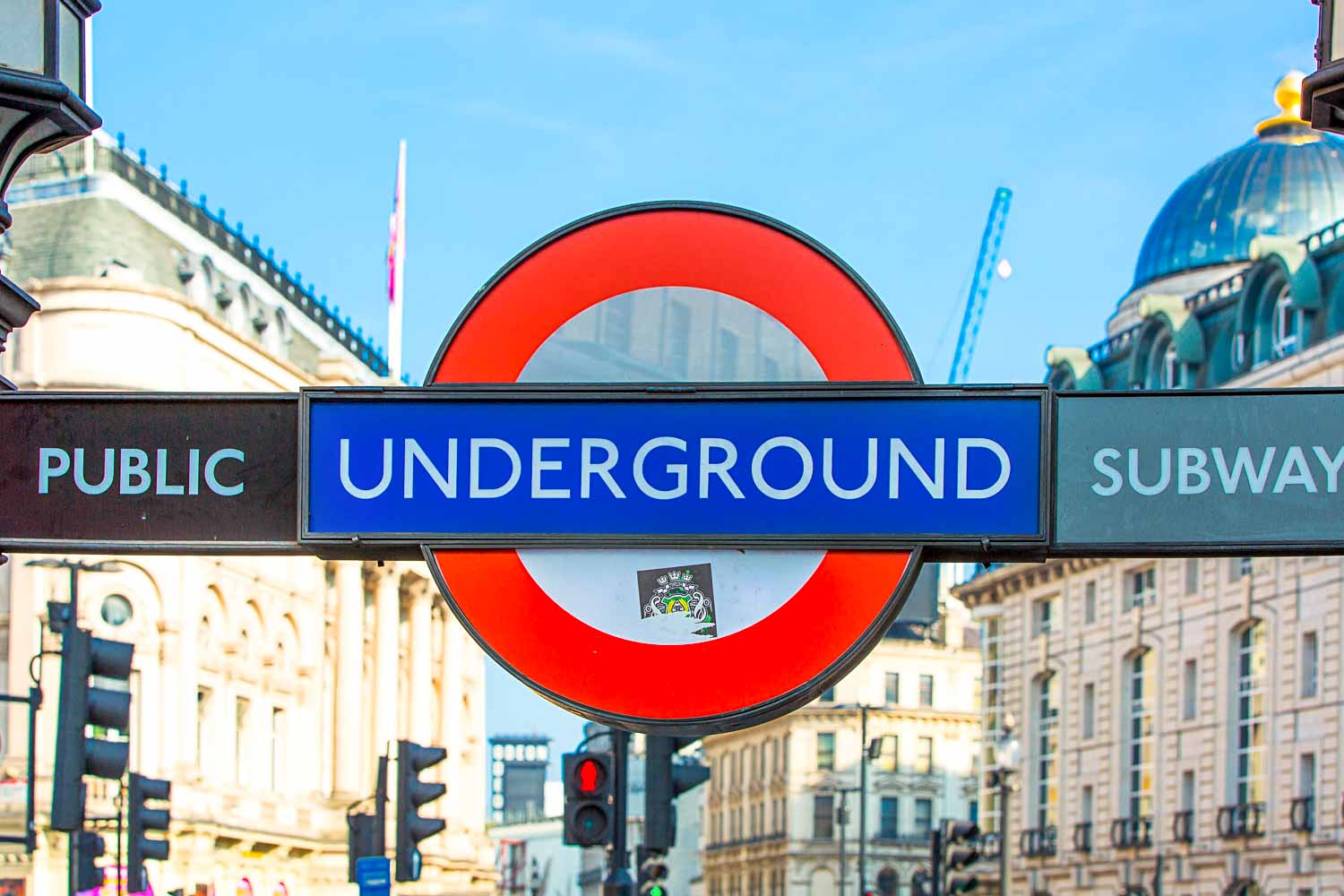 Tube roundel with the words Underground against a blue sky in a London street - my tips for the London Underground with toddlers and preschoolers