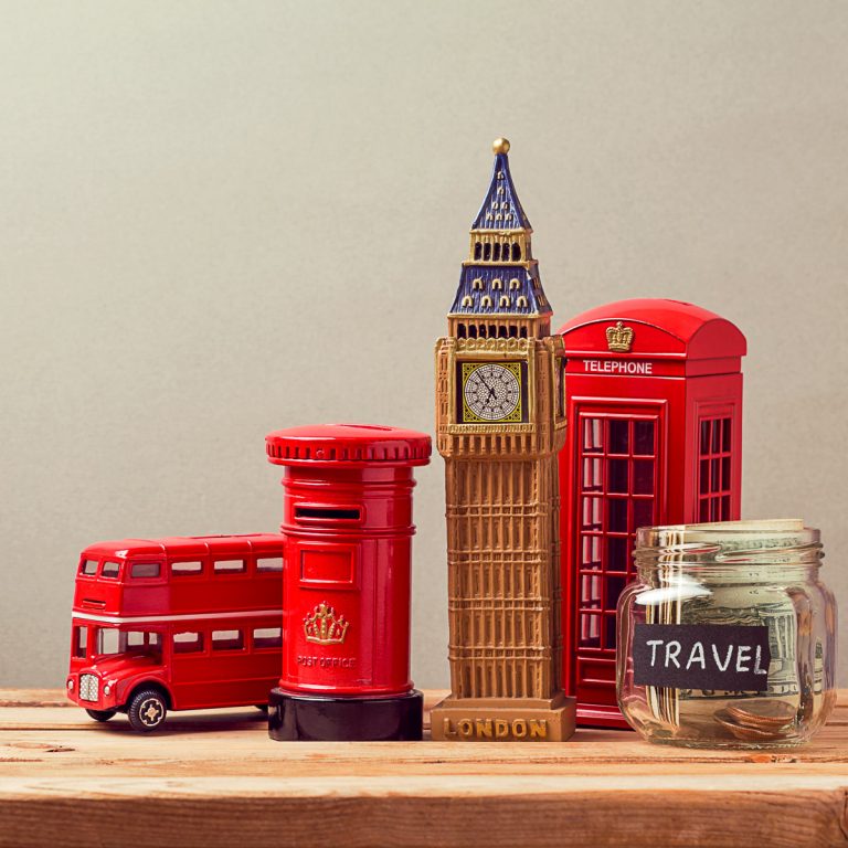 Model red doublechecker bus with red postbox, phone box, model of Big Ben and jar marked travel with money inside - how to save on London with kids, my tips for finding the best discounts and deals for a London family holiday