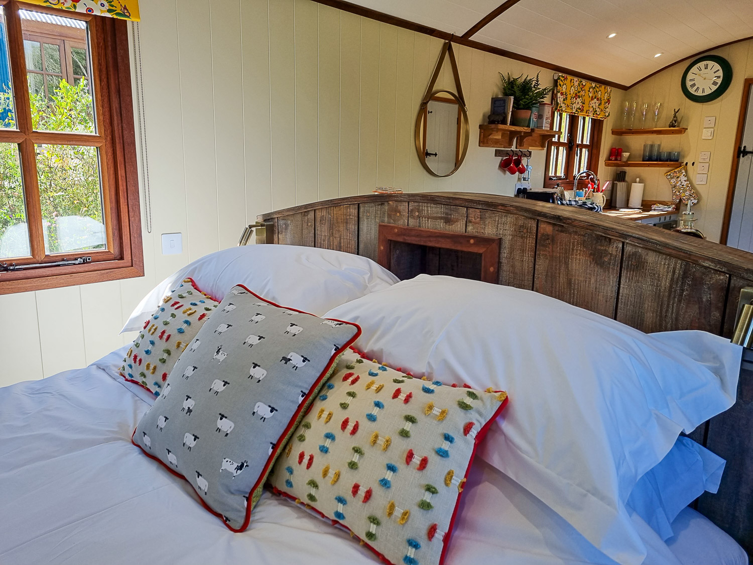 View across the bed to the kitchen, with stove in one of the shepherd's huts at Dittisham Hideaway - my review of the Devon luxury glamping site