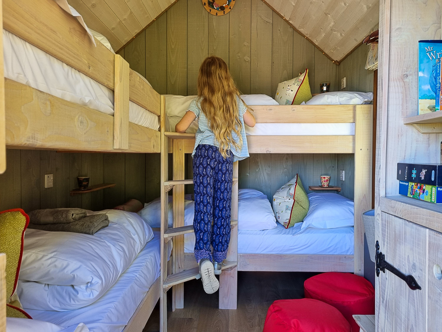 My daughter climbs the ladder towards the four bunk beds in one of the Shepherd's Huts, designed for a stay at Dittisham Hideaway with kids