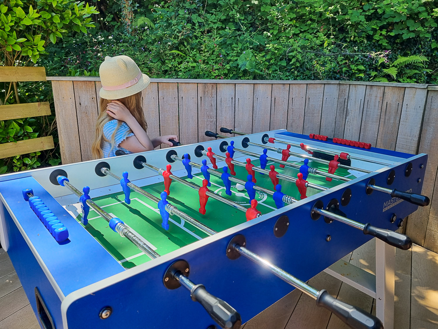 My daughter stands next to the table football (Fussball) table during a stay at Dittisham Hideaway with kids