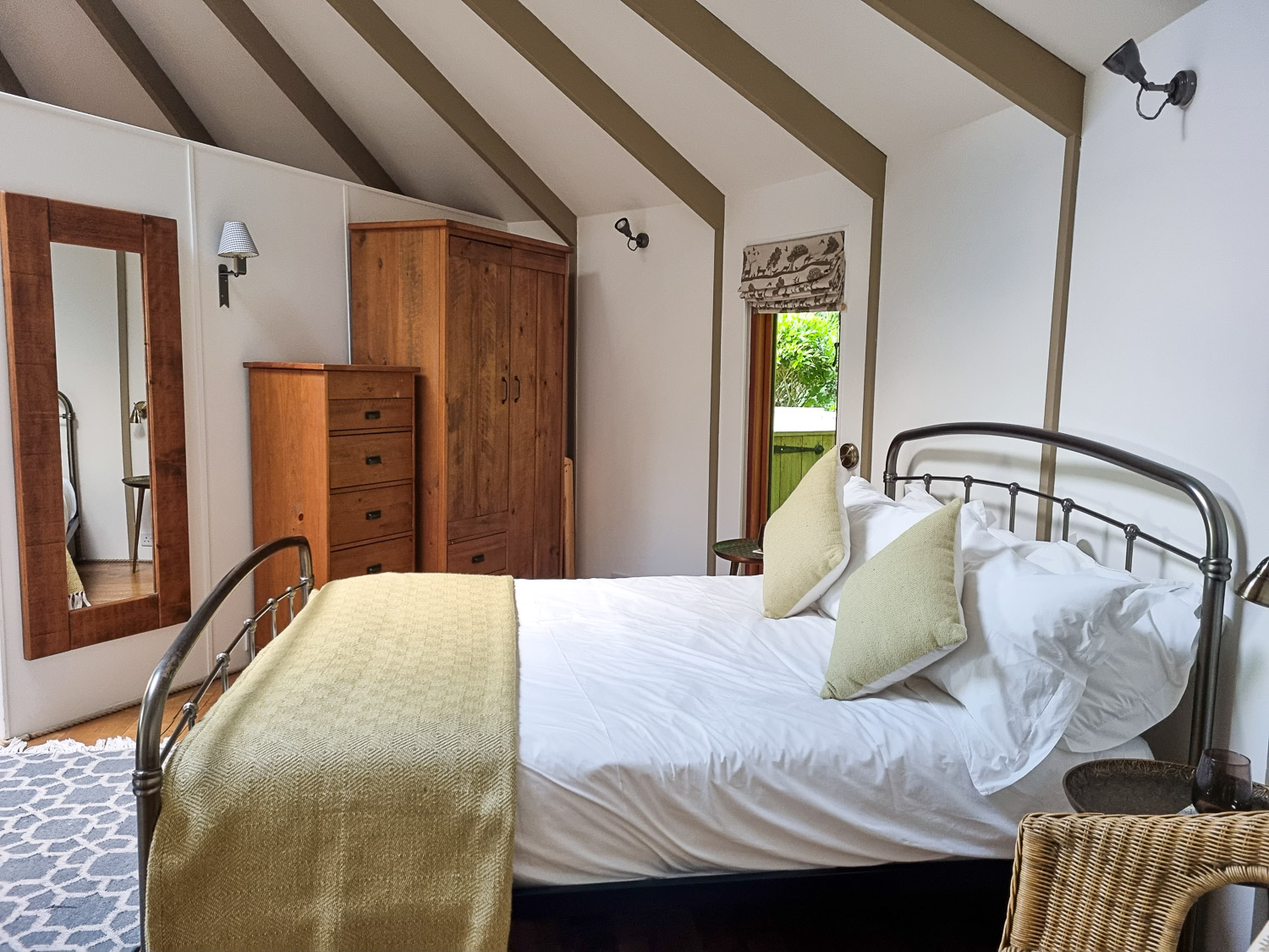 View across the double bed to wooden drawers and wardrobe beyond - my Dittisham Hideaway review after a stay at the Devon luxury glamping site