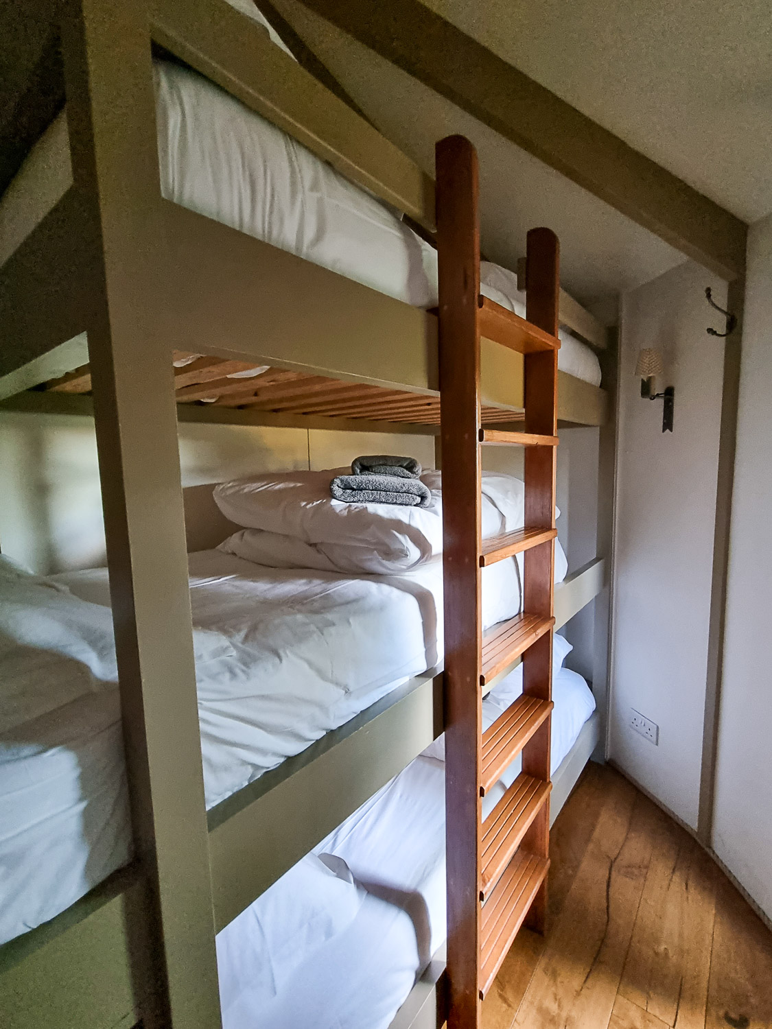 View along the side of the triple bunk beds in Owl Treehouse - my review of Dittisham Hideaway with kids