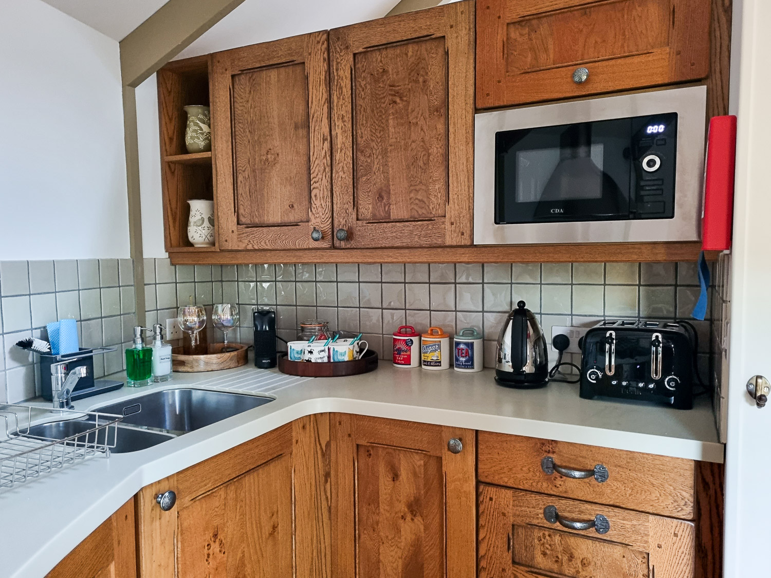 View of part of the kitchen at owl treehouse with microwave, toaster, coffee and tea making facilities - my Dittisham Hideaway review