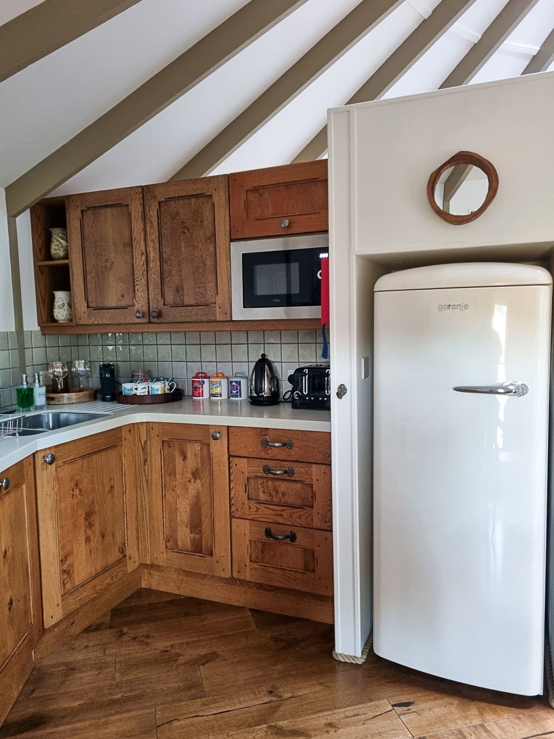 View of part of the kitchen at owl treehouse with large retro white fridge, toaster, coffee and tea making facilities - my Dittisham Hideaway review