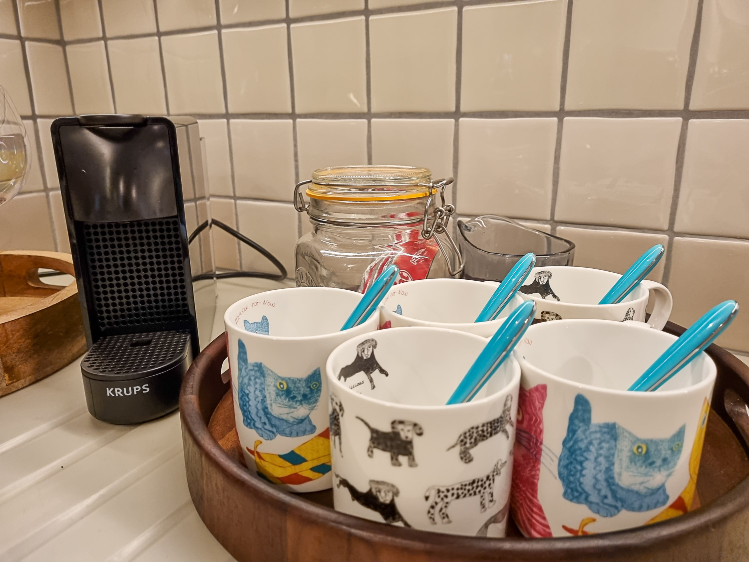 Nespresso machine and tray with five mugs, and jar of kitkats in the kitchen of Owl treehouse - my Dittisham Hideaway review after a stay at the luxury Devon glamping site