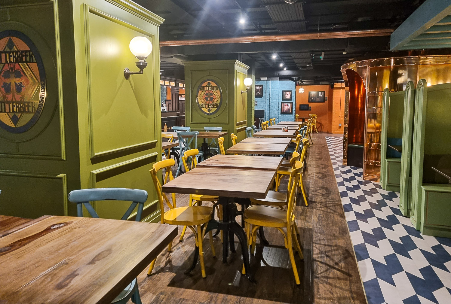 Woodne tables and green walls at the cafe serving butterbeer after the Harry Potter Photo Exhibition in Covent Garden