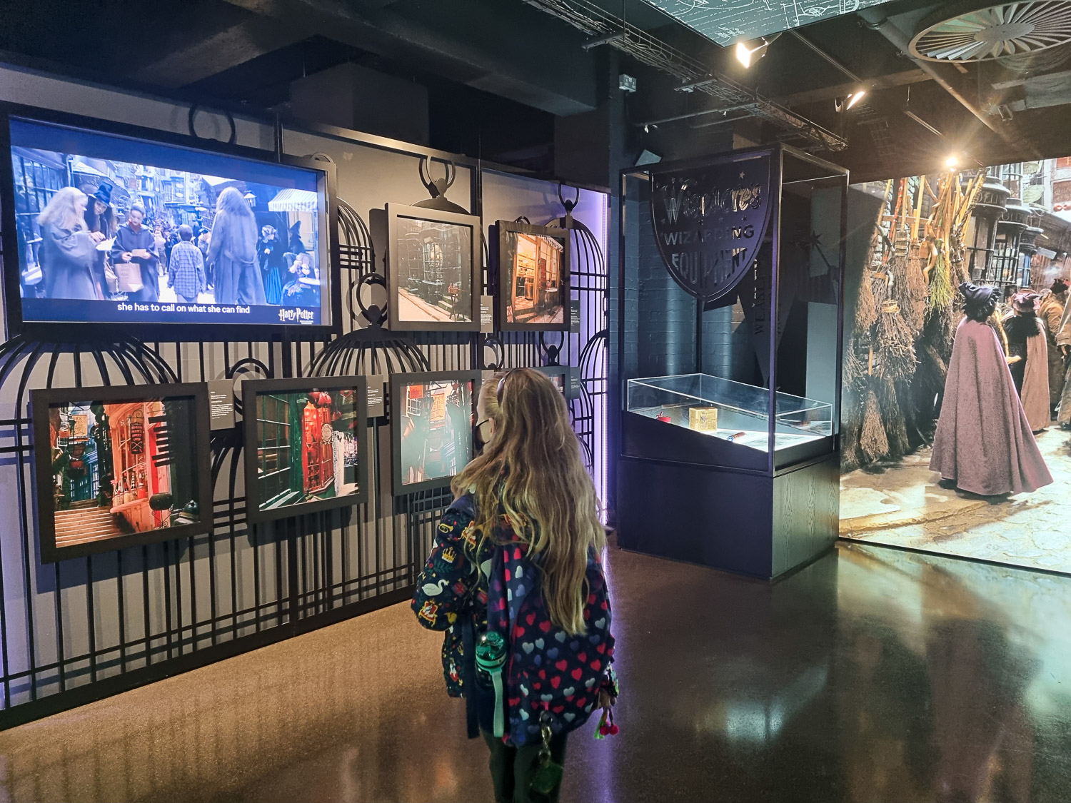 My daughter looks at photos and video with scenes from the movies during a visit to London's Harry Potter Photographic Exhibition with kids