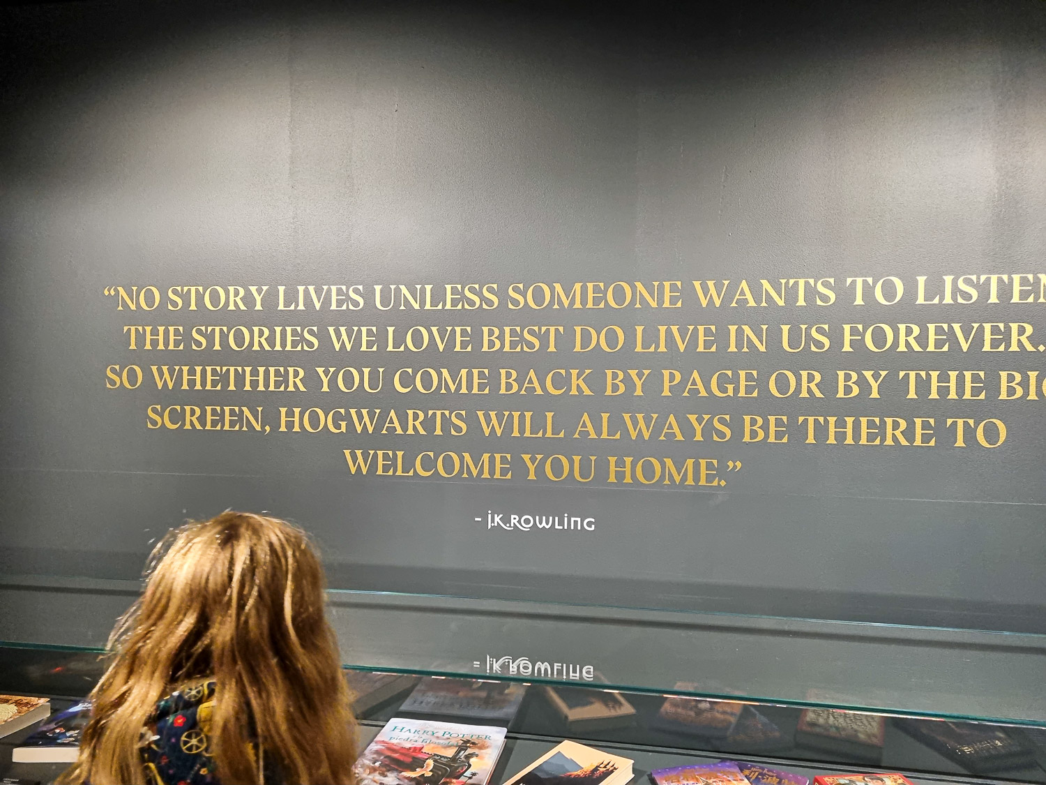 My daughter reads a quote by JK Rowling at the start of the Harry Potter photo exhibtion in London - my review of a visit with kids