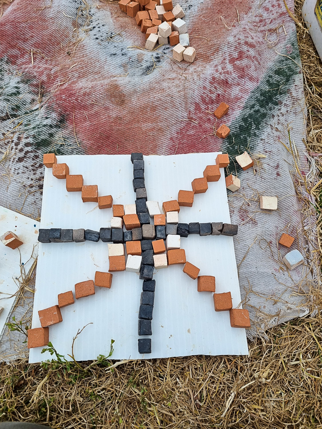Beginning of a mosaic using brown, white and black squares on a white background, made as one of the activities at the temporary medieval village in Corfe Castle for kids