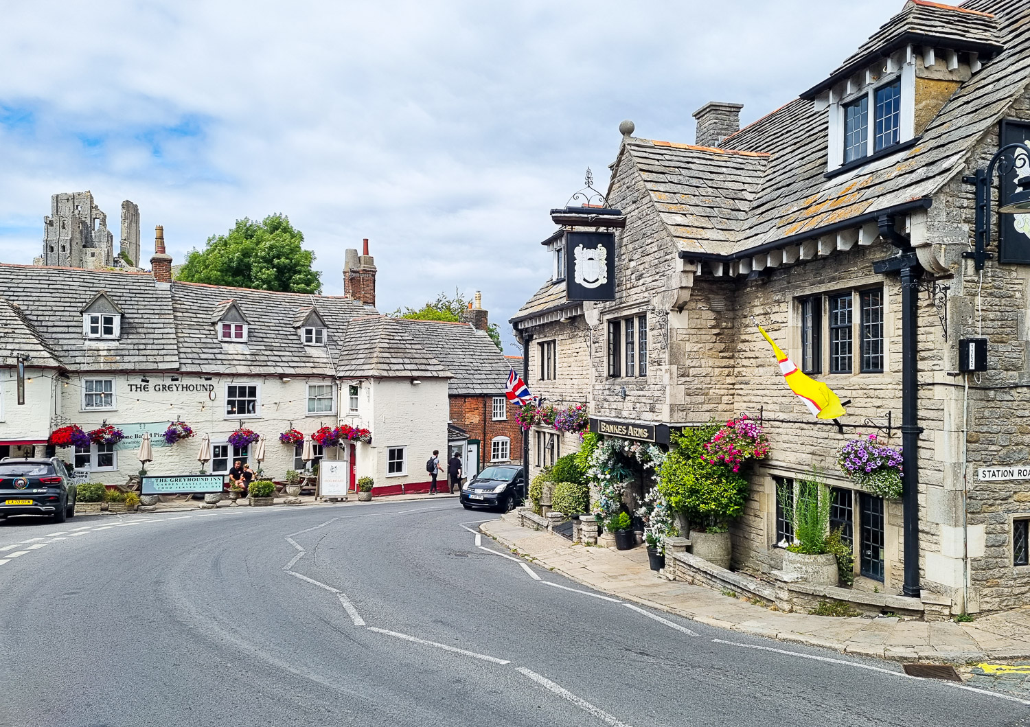 View of two old pubs in the village of Corfe with the ruins of the castle just seen in the background - a day out at Corfe Castle with kids