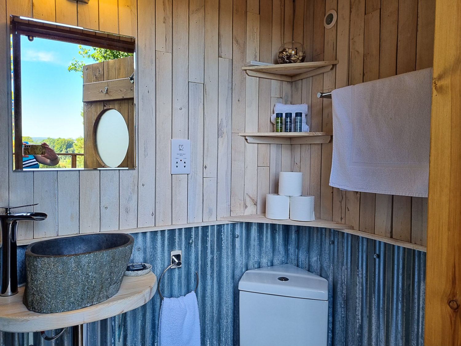 View of the small bathroom adjacent to Knole Luna Dome with stone sink, toilet and shelves visible - my review of luxury glamping in Kent with kids