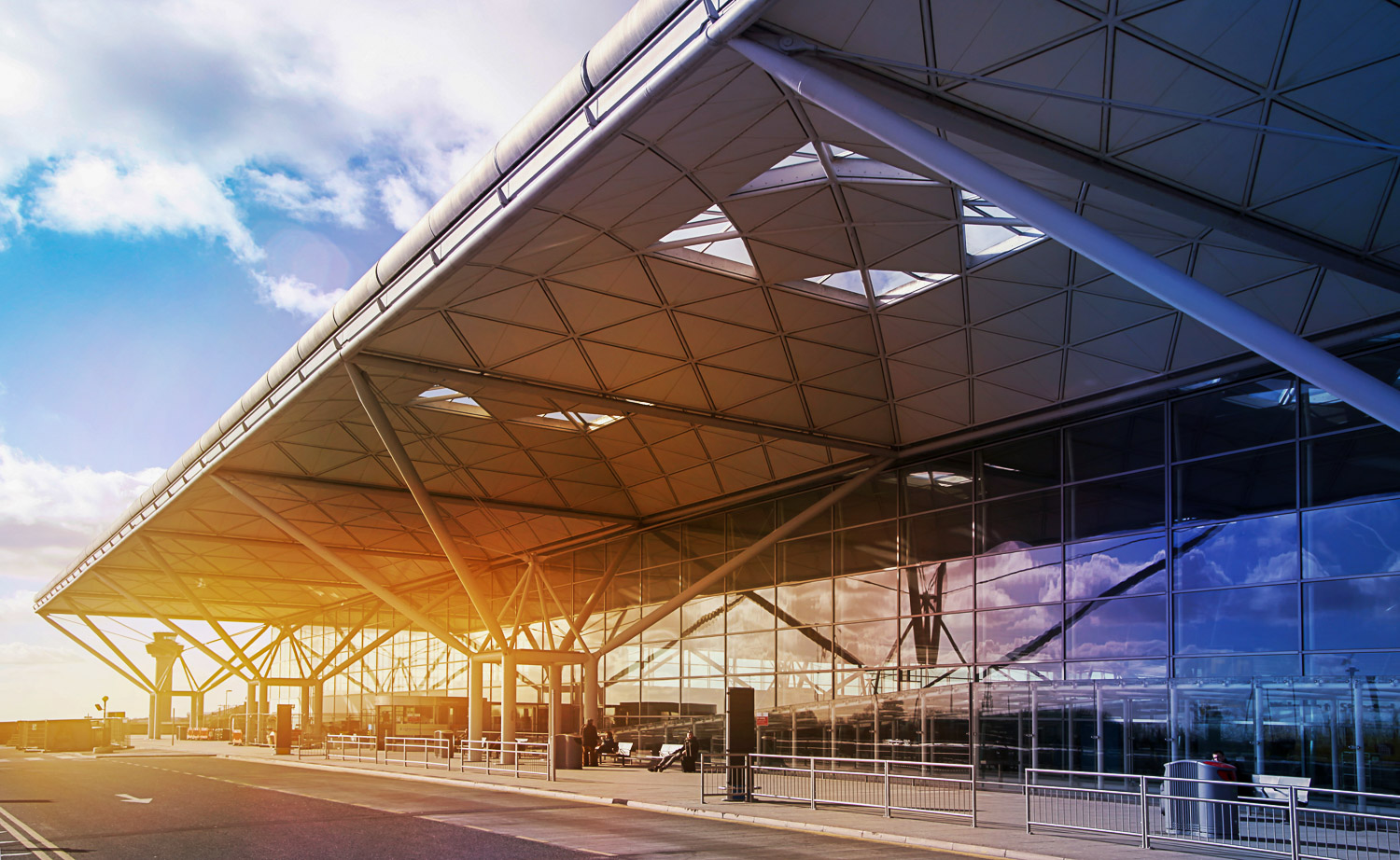 Exterior of Stansted Airport with the sun behind the building - my tips on the best way to travel from Stansted to central London