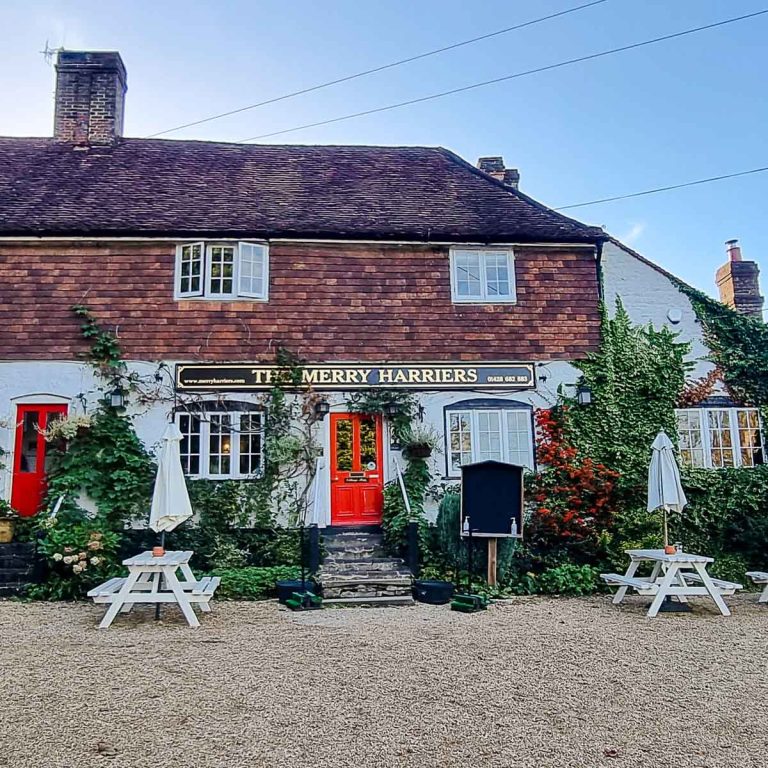 Exterior of the Merry Harriers pub in Surrey against a blue sky - my review of the Family Wing at the Merry Harriers and its llama walk in Surrey