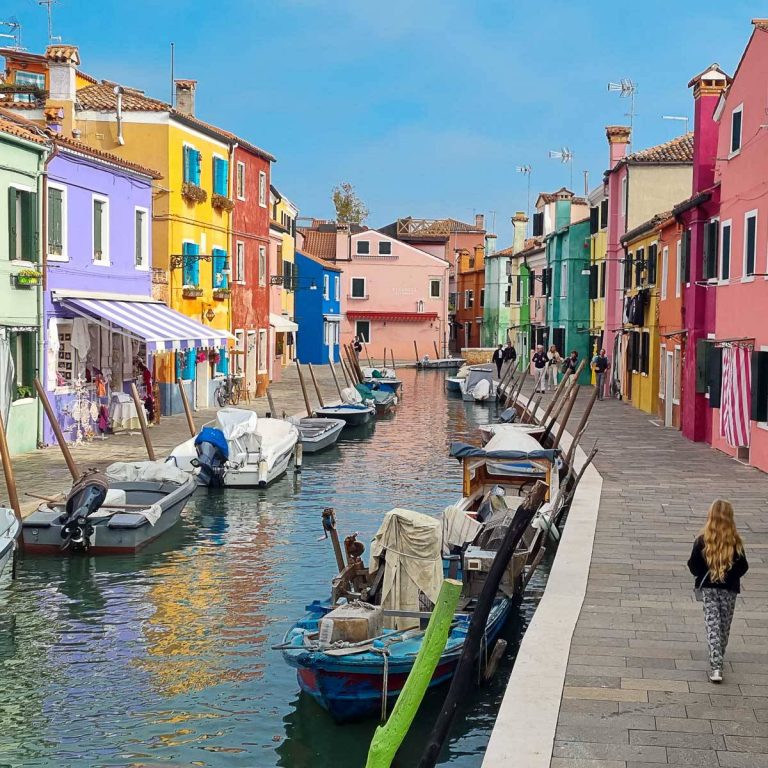 My daughter walks along the canalside past the brightly coloured houses of Burano - here's how to spend one day in Burano with kids