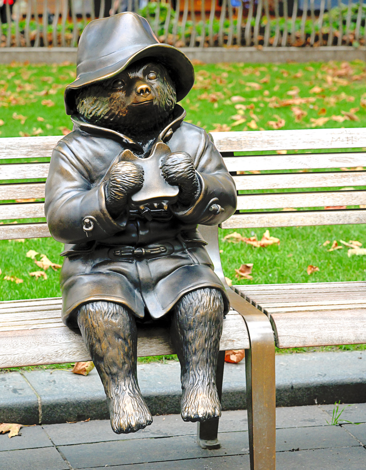 Statue of Paddington Bear with marmalade sandwich, sitting on a bench in Leicester Square - one of a string of statues to spot if you're looking for Paddington Bear in London with kids