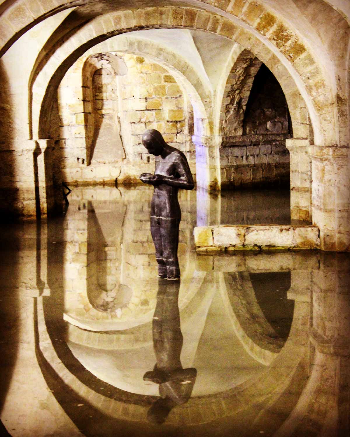 Anthony Gormley statue in the flooded vault of Winchester cathedral