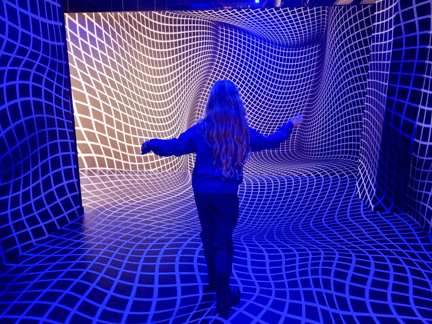 My daughter inside a room with apparently warped floors and walls at the London Museum of Illusions - a visit is one of many things to do at May half-term in London with kids