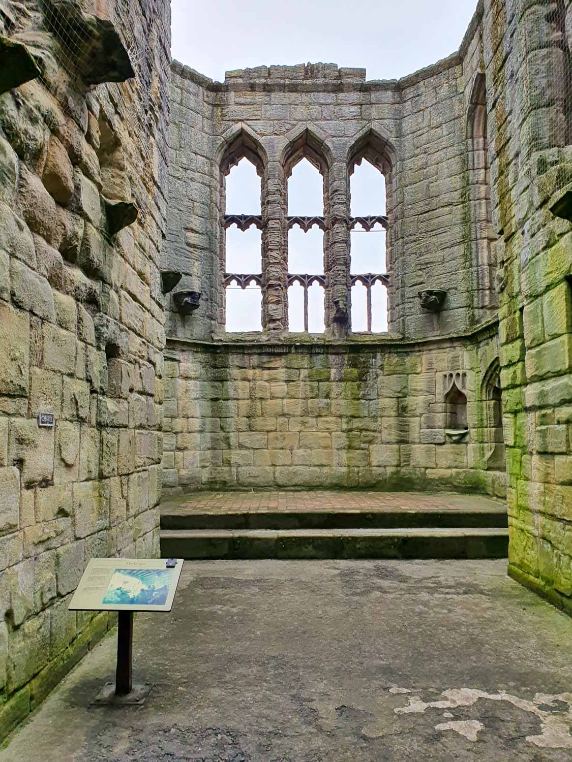 View of the ruined chapel with its arched windows in Warkworth Castle, Northumberland - exploring the castle with kids