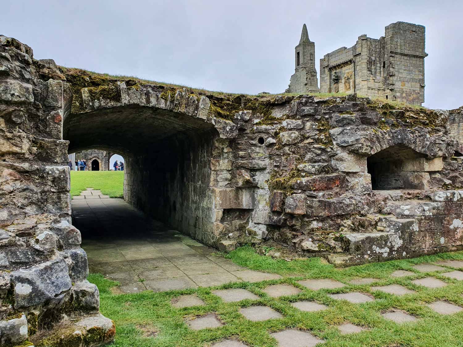 View through a stone tunnel to part of the inner court and remains of stone towers at Warkworth Castle in Northumberland - our review of a day out with kids