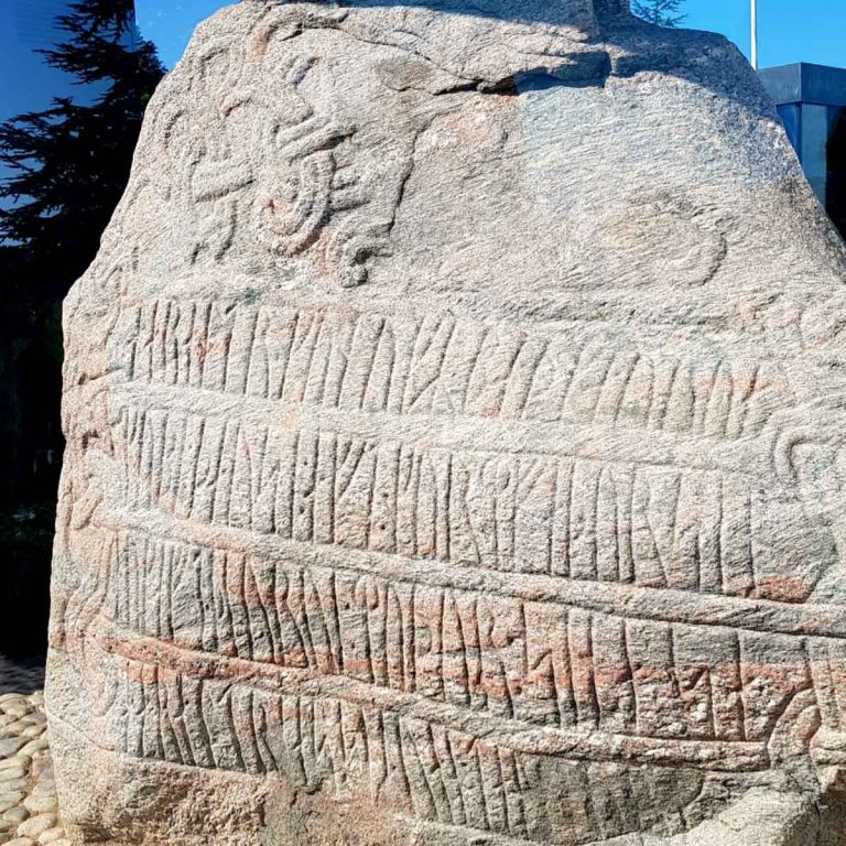 Ancient stone at Kongernes Jelling in Jutland, Denmark with rune markings on - the best kids books about denmark